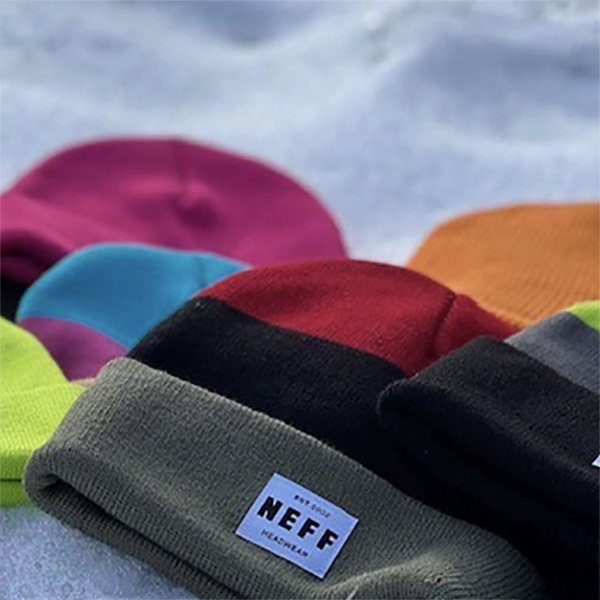a variety of neff beanies in different colors displayed in the snow